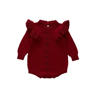 Romper in maglia rossa per neonata con volant e motivo a rombi per la stagione autunnale.