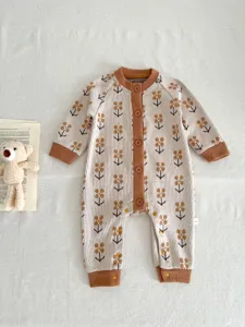 Cute knitted baby romper with brown floral pattern, long sleeves and button closure details.