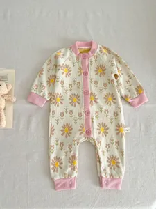 Baby knit romper detailed view, cute daisy pattern autumn infant clothing with buttons.