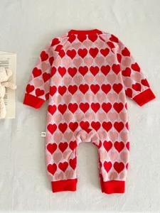 Infant knit romper featuring a charming red and pink heart pattern with cozy ribbed cuffs.