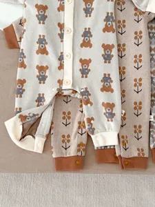 Knit baby romper detail, cute bear pattern, soft fabric, snap buttons, cozy infant wear.