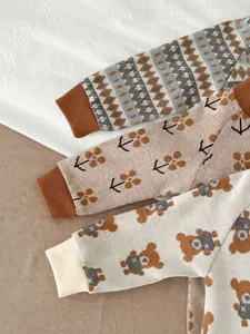 Knit baby romper detail shot featuring cute bear and floral pattern sleeves, soft cotton fabric.