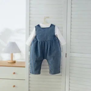 Ensemble bébé fille avec haut à manches longues blanc et barboteuse en jean denim.