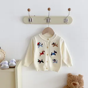 Close-up detail of infant knit cardigan with cute embroidered dogs and wooden buttons.