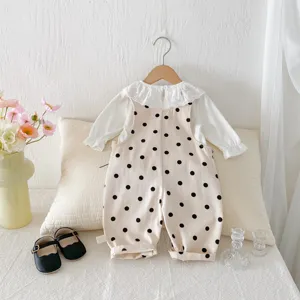 Close-up of baby girl polka dot overall and lace blouse set in cozy ins style room detail.