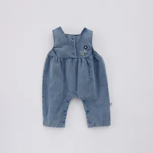 Vue détail barboteuse denim bébé, combinaison bleue sans manches avec broderie florale mignonne.