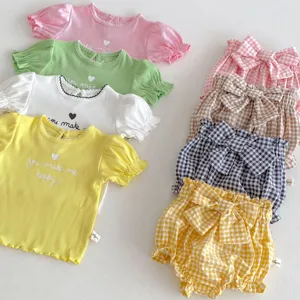 Dettagli di magliette estive a maniche corte e pantaloncini a quadri per neonata.