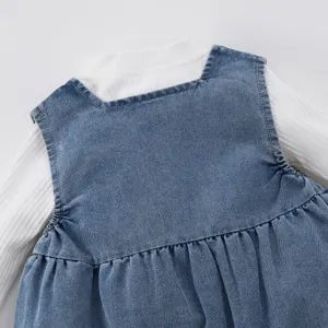 Détails ensemble bébé fille 0-3 ans, haut côtelé blanc et robe chasuble en jean.