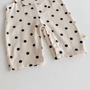 Infant baby polka dot romper detail view, featuring cute black dots and convenient snap buttons.