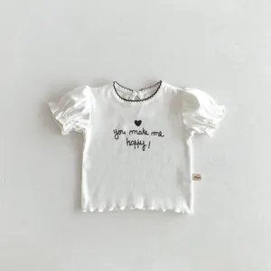 Dettaglio t-shirt bianca a costine, maniche a palloncino, collo volant nero, stampa.