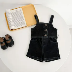 Vista dettagliata del set in denim per neonati, top smanicato e pantaloncini, lavaggio scuro.
