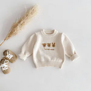 Detailed view of baby knit sweater featuring cute embroidered animals and ribbed cuffs.