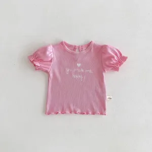 Dettaglio t-shirt manica corta bambina rosa, tessuto a costine carino e maniche a palloncino.
