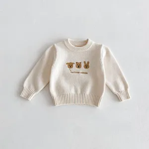 Close-up detail of infant knit sweater with cute animal embroidery and soft texture.