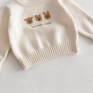 Close-up detail of infant knit sweater with cute animal embroidery and crewneck design.
