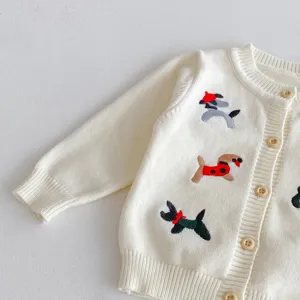 Detail view of infant knit cardigan with cute dog embroideries and wooden buttons.