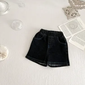 Vista dettagliata di pantaloncini in denim nero per bambini con cuciture blu, vita elastica e tasche.