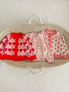 Charmant ensemble de gilets en tricot pour bébés avec motifs de cœurs et fleurs.