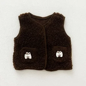 Close-up detail shot of a brown baby fleece vest featuring cute bunny ear pocket accents.