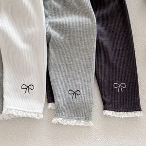 Detail shot of infant cotton waffle leggings with cute bow embroidery and delicate lace trim