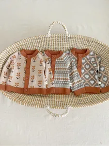 Ensemble de cardigan en tricot pour bébé avec motifs floraux et jacquard de cœurs.