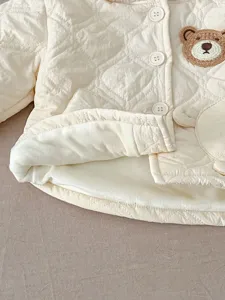 Baby quilted fleece-lined jacket detail shot, soft plush lining, cute bear patch accent.