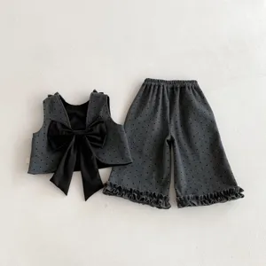 Girls cute spring polka dot outfit set with large bow vest and ruffled wide-leg pants.