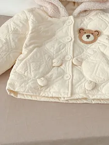 Close-up of baby winter hooded padded jacket with cute bear embroidery and warm fleece lining.