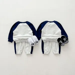Vista di dettaglio della felpa e dei pantaloni da neonato con simpatico design a maniche raglan.