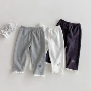 Infant baby girl ribbed leggings detail view featuring cute bow embroidery and lace hem.