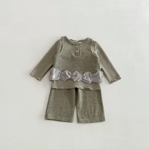 Detailed view of children waffle knit three-piece set with elegant ruffle waist detail.