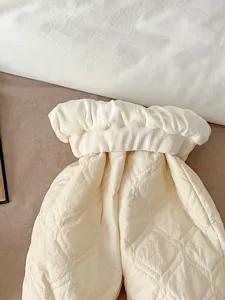 Baby quilted winter warm trousers detail view, soft thick cream infant clothing.