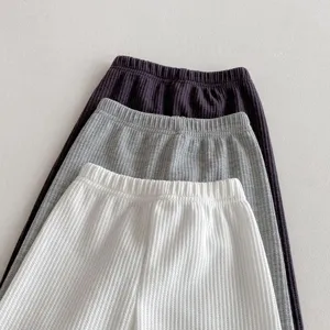 Detailed close-up view of infant waffle knit leggings in three colors, soft cozy fabric.