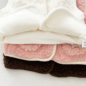 Detail shot of thick lamb wool baby vest, soft fluffy texture, cute winter clothing.