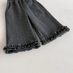 Cute toddler girls dark grey polka dot flare pants with delicate ruffled cuffs detail.