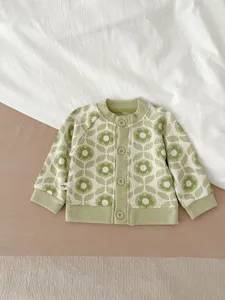 Gros plan de la cardigan en tricot floral vert et blanc, montrant texture et boutons.
