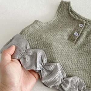 Baby girls waffle knit sleeveless vest with contrast ruffles and buttons, cute daily toddler top detail.