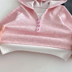 Nahaufnahme eines rosafarbenen Kinder Hoodie im Fake-Zweiteiler-Look mit Knöpfen.