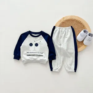 Vista dettagliata del set felpa raglan e pantaloni per piccoli bambini con stampa di occhi.