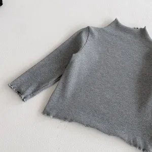 Grey ribbed long sleeve kids top detail showing soft knit texture, mock neck and cute ruffle cuffs.
