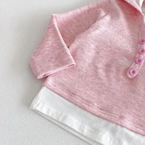 Nahaufnahme von rosa meliertem kinder hoodie fake zweiteiler mit weissen knoepfen detail.