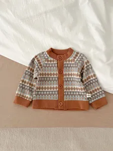 Détail de gilet pull en tricot pour bébé avec motif jacquard géométrique et boutons.