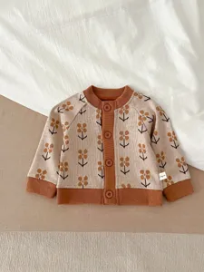 Vue détaillée du gilet en tricot pour bébé avec motif floral et finitions côtelées.