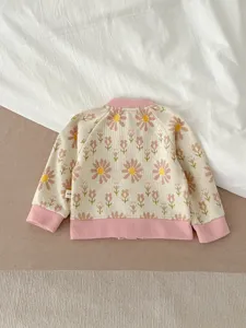 Vue détaillée du dos d'un joli cardigan tricoté pour bébé avec des motifs floraux doux.