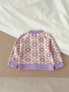 Détail de gilet tricoté rétro bébé, joli motif géométrique avec bordures côtelées.