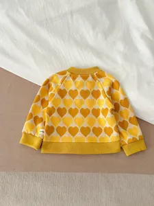 Mignon gilet cardigan en tricot motif cœur jaune pour enfants, beau détail de bébé.