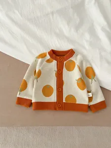 Vue détaillée du gilet en tricot pour bébé avec motif jacquard de fruits orange et boutons.
