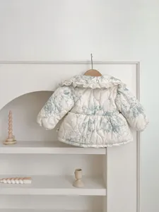 Detail shot of infant quilted padded coat with blue floral print and cute ruffled collar.