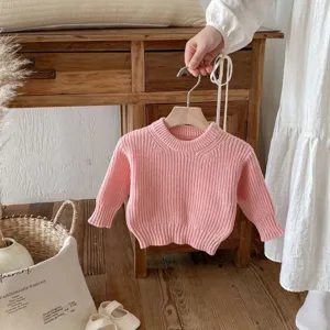 Primer plano del suéter rosa de punto para bebés, detalle cómodo y suave de manga larga.