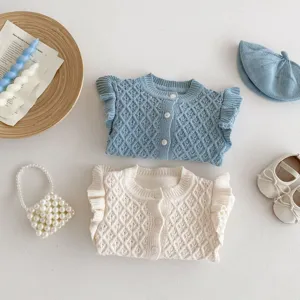 Infant baby girl knit cardigan sweater detail featuring rhombus jacquard and fly sleeves.